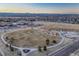 Aerial view of community with nearby school, park, and stunning mountain backdrop at 12988 E 108Th Pl, Commerce City, CO 80022
