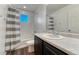 Bright bathroom with a tub and shower featuring gray striped curtains and a large vanity at 12988 E 108Th Pl, Commerce City, CO 80022
