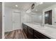 Bathroom features wood-look flooring, double sinks, a large mirror, and modern lighting at 12988 E 108Th Pl, Commerce City, CO 80022
