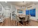 Dining area featuring wood floors, a modern light fixture, and large windows providing natural light at 12988 E 108Th Pl, Commerce City, CO 80022