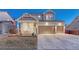 Inviting home with a covered porch, American flag, three-car garage, and landscaped front yard at 12988 E 108Th Pl, Commerce City, CO 80022
