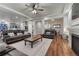 Spacious living room with fireplace, wood floors, plush seating, and dining area at 12988 E 108Th Pl, Commerce City, CO 80022