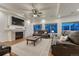 Spacious living room with fireplace, plush sofas, tray ceilings, and large windows at 12988 E 108Th Pl, Commerce City, CO 80022