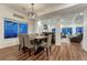 Open-concept living and dining area with wood floors, large windows, and comfortable furnishings at 12988 E 108Th Pl, Commerce City, CO 80022