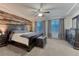 Beautiful bedroom with wooden accent wall, tray ceiling, and large windows provides natural light at 12988 E 108Th Pl, Commerce City, CO 80022