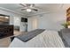 Spacious carpeted bedroom with a mounted TV, dresser, and convenient access to the bathroom at 12988 E 108Th Pl, Commerce City, CO 80022