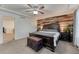 Bedroom featuring wood accent wall, a ceiling fan, and dark wood furniture on neutral carpet at 12988 E 108Th Pl, Commerce City, CO 80022