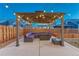Inviting covered patio featuring a cozy seating area and ambient string lights at 12988 E 108Th Pl, Commerce City, CO 80022
