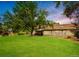 Spacious backyard with a large tree and a play structure at 4180 S Yukon Way, Lakewood, CO 80235
