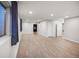 Large basement room with light flooring, neutral walls, and two doorways for flexible use at 4180 S Yukon Way, Lakewood, CO 80235