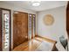Warm foyer featuring hardwood floors, decorative glass sidelights, and a wooden front door at 4180 S Yukon Way, Lakewood, CO 80235