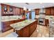 Well-equipped kitchen with large island, granite counters, custom cabinets, and stainless steel appliances at 4180 S Yukon Way, Lakewood, CO 80235