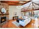 Living area featuring a stone fireplace, wood-beamed ceiling, and an open layout at 4180 S Yukon Way, Lakewood, CO 80235