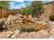 Beautiful backyard water feature with cascading rocks and lush landscaping, creating a tranquil and natural ambiance at 4180 S Yukon Way, Lakewood, CO 80235