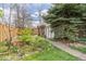 Landscaped back yard featuring a grassy lawn, a shed, flower beds, and wooden fencing at 2514 N Humboldt St, Denver, CO 80205