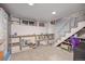 Basement features built in shelving, carpeted floors, and a staircase at 2514 N Humboldt St, Denver, CO 80205