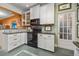 Bright kitchen with white cabinetry, black appliances, and mosaic tile backsplash at 2514 N Humboldt St, Denver, CO 80205