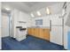 Compact kitchen features a stove, sink, refrigerator, and white cabinets at 2514 N Humboldt St, Denver, CO 80205