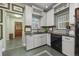 Charming kitchen with white cabinets, black appliances, and unique stone flooring at 2514 N Humboldt St, Denver, CO 80205