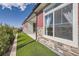 Exterior home view showcasing stone and wood trim with artificial turf along the foundation at 4955 N Picadilly Ct, Aurora, CO 80019