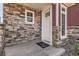 Close up of front door showcasing stone accents and siding, including an Oakwood Life welcome mat at 4955 N Picadilly Ct, Aurora, CO 80019