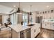 Modern kitchen featuring stainless steel appliances, island, and hardwood floors overlooking living area at 4955 N Picadilly Ct, Aurora, CO 80019