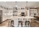 Bright, open kitchen featuring white cabinets, stainless steel appliances, and a large island with seating at 4955 N Picadilly Ct, Aurora, CO 80019