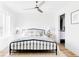 Serene bedroom with a black metal bed frame, ceiling fan, and minimalist decor at 1168 S Reed Way, Lakewood, CO 80232