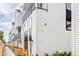 Modern townhouse row featuring wood fencing, white siding, black trim, and large windows for ample natural light at 1168 S Reed Way, Lakewood, CO 80232