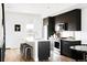 Modern kitchen with black cabinetry, stainless steel appliances, and a center island with seating at 1168 S Reed Way, Lakewood, CO 80232