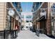 Stone walkway between brick buildings featuring hanging string lights and various storefront signs at 1168 S Reed Way, Lakewood, CO 80232