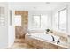 Bright primary bathroom features a soaking tub with tile surround, a window view, and a glass block shower, offering a spa-like retreat at 5550 Preserve Dr, Greenwood Village, CO 80121