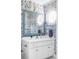 Charming bathroom with blue-patterned wallpaper, octagonal window, mosaic mirror, and white vanity, adding a touch of elegance at 5550 Preserve Dr, Greenwood Village, CO 80121