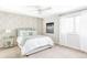 Cozy bedroom with a patterned accent wall, soft carpet, and a large window, creating a peaceful and comfortable atmosphere at 5550 Preserve Dr, Greenwood Village, CO 80121