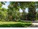 Beautiful home exterior featuring a well-manicured lawn, mature trees, and a circular driveway at 5550 Preserve Dr, Greenwood Village, CO 80121