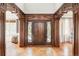 Grand foyer featuring custom woodwork, a stylish front door with sidelights, and ceramic tile flooring at 5550 Preserve Dr, Greenwood Village, CO 80121