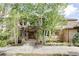 Charming brick home featuring a beautiful stone walkway, lush landscaping, and mature aspen trees at 5550 Preserve Dr, Greenwood Village, CO 80121