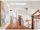 Sunlit hallway featuring hardwood floors, a skylight, and a view of the staircase with wooden accents, exudes warmth and charm at 5550 Preserve Dr, Greenwood Village, CO 80121