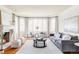 Bright and airy living room featuring hardwood floors, a fireplace, and large windows with elegant drapery at 5550 Preserve Dr, Greenwood Village, CO 80121