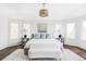 A beautifully staged primary bedroom with large windows, a decorative chandelier, and refined details for a relaxing atmosphere at 5550 Preserve Dr, Greenwood Village, CO 80121
