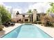 Stunning backyard pool with adjacent seating area and elegant home exterior with brick chimney at 5550 Preserve Dr, Greenwood Village, CO 80121
