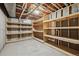 Unfinished basement with exposed ceiling, lighting, and built in wooden shelving at 14186 E Hampden Pl, Aurora, CO 80014