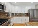 Close up of the kitchen with white cabinets, stainless appliances, and beautiful granite countertops at 14186 E Hampden Pl, Aurora, CO 80014
