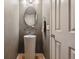 Stylish powder room with pedestal sink, modern fixture, and decorative mirror at 14186 E Hampden Pl, Aurora, CO 80014