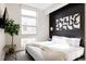 Bright bedroom with a black accent wall, modern art, and a large window providing natural light at 2880 Zuni St # 408, Denver, CO 80211