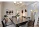 A dining room table with modern chandelier and access to the stairwell and kitchen at 4543 S Auckland Ct, Aurora, CO 80015