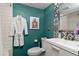 Teal-walled bathroom with a toilet and shower at 100 S Clarkson St # 105, Denver, CO 80209