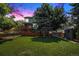 Expansive backyard with a large deck, mature trees, and a storage shed at 3647 S Uravan St, Aurora, CO 80013