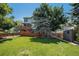 Sprawling backyard with a lush lawn, mature trees, a storage shed, and a wooden deck at 3647 S Uravan St, Aurora, CO 80013