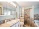 Bathroom featuring single sink, glass block accent, tub/shower combination and tile floors at 3647 S Uravan St, Aurora, CO 80013